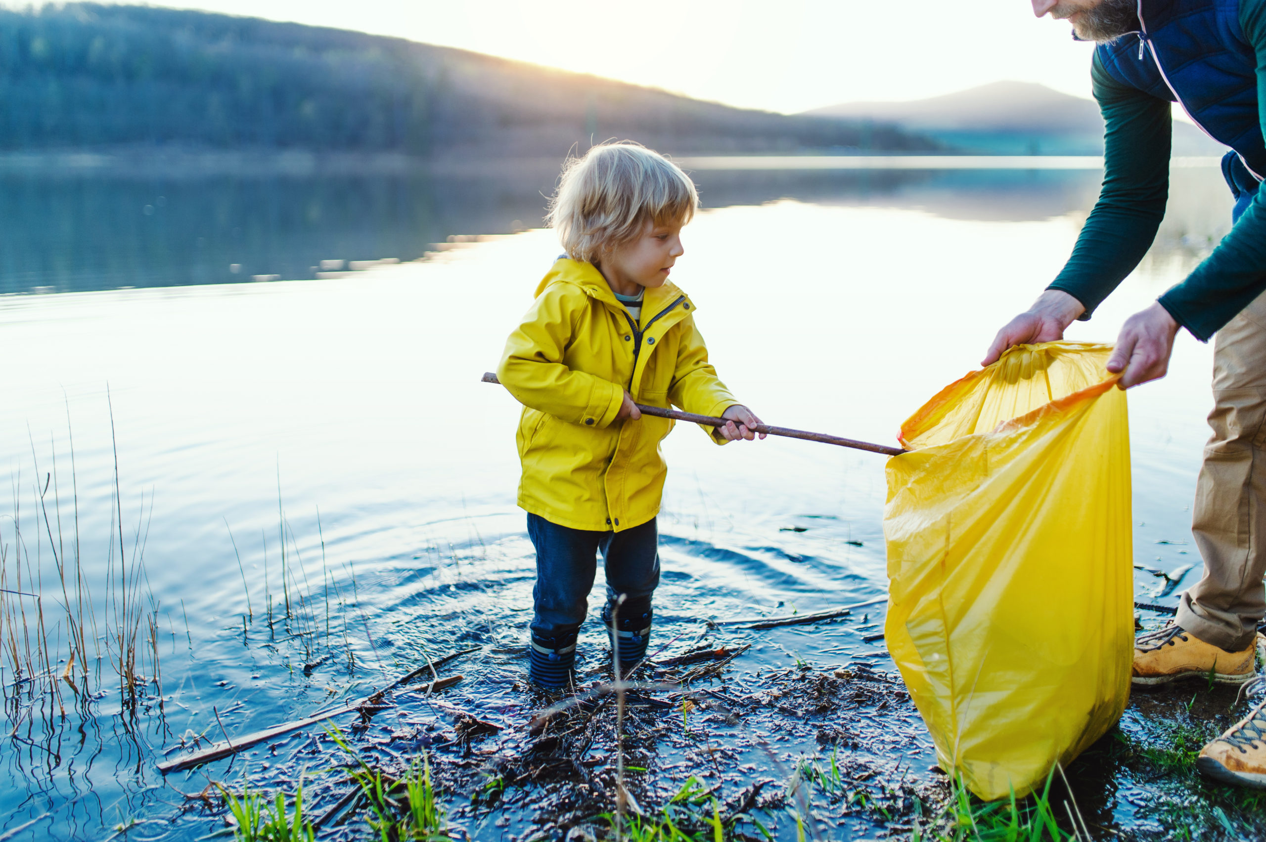 Un père et son petit garçon ramassent des déchets pour préserver l'eau du lac