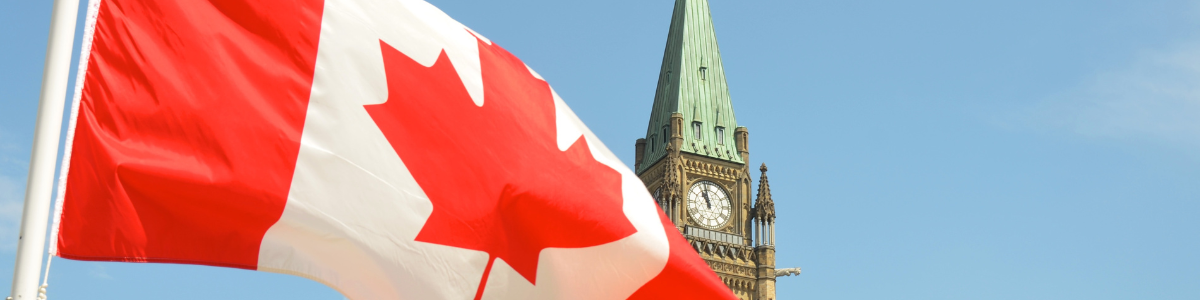 Canadian flag waving in front of the Parliament Building on Parliament Hill in Ottawa